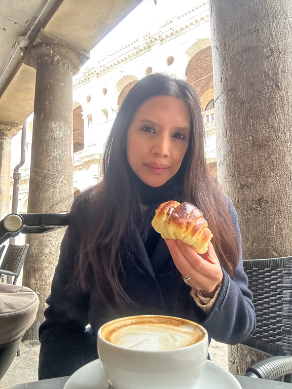 Lisa Rivera holding a brioche outside Soraru Pasticceria in Vicenza Italy - where to eat in Vicenza Italy