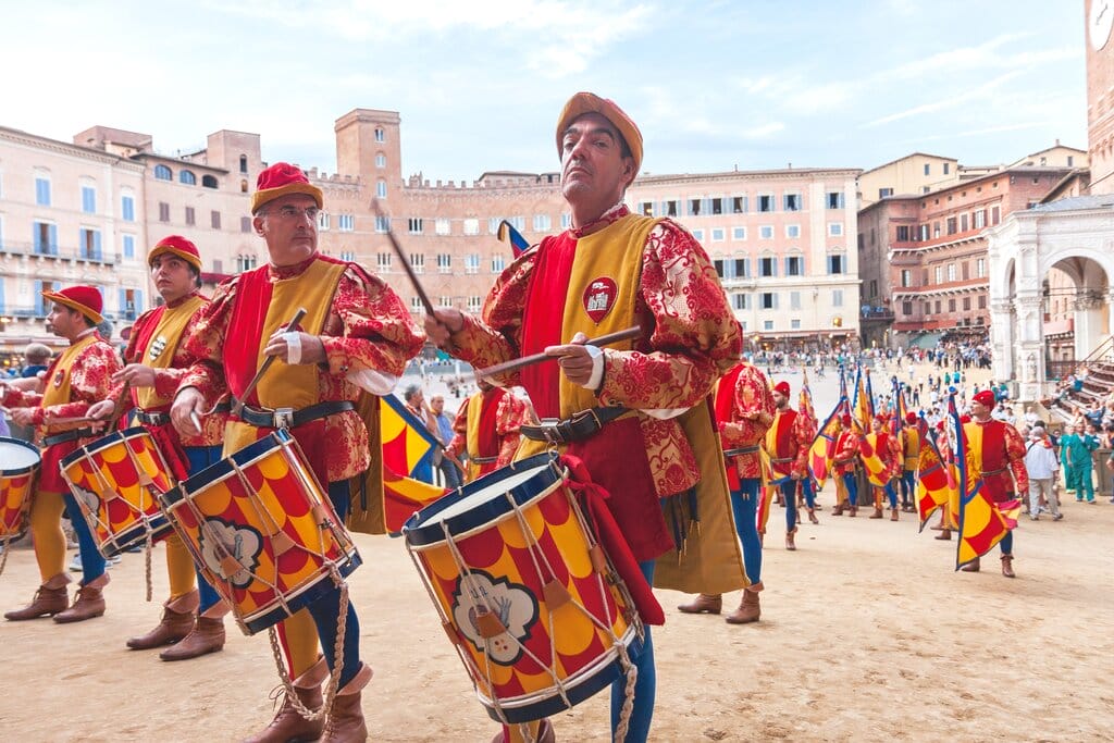Musicians in colorful dress playing drums for the Palio race in Siena Italy