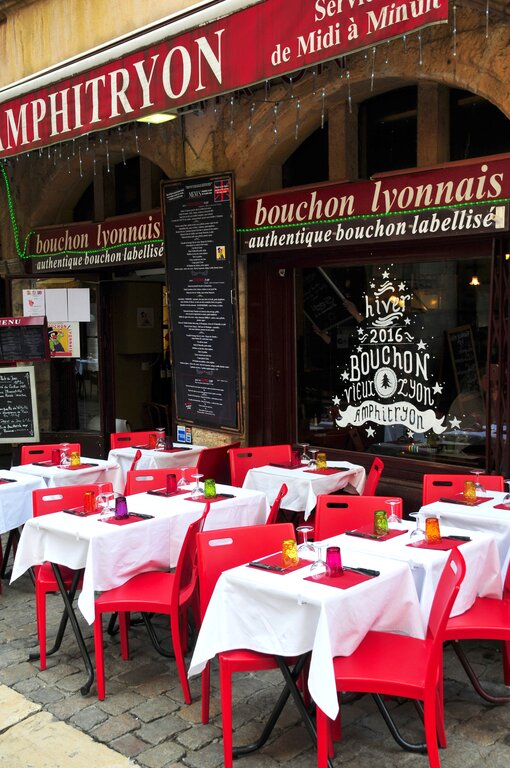 A bouchon in Lyon France with tables and chairs outside
