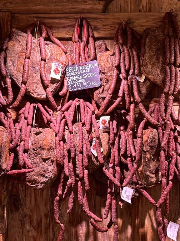 Speck and sausages hanging in a shop in Bolzano Italy