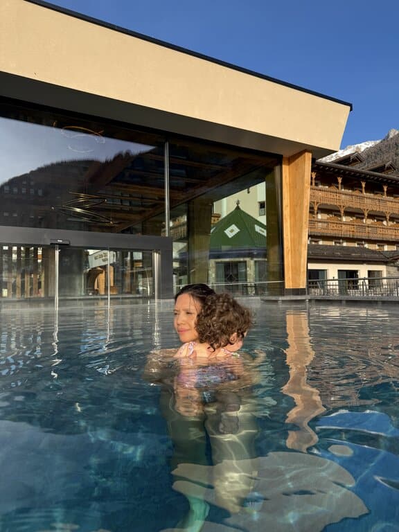 Lisa Rivera holding her baby daughter in the pool at Dolce Casa Resort in Moena, Dolomites Italy in winter