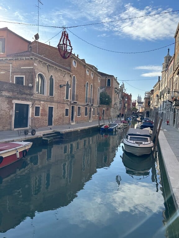 Boats parked on a quiet canal street in Venice Italy