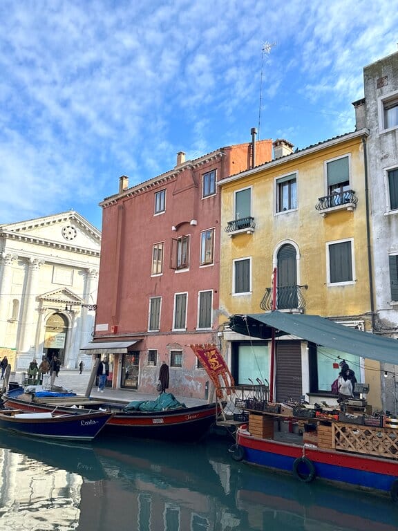 Market on a boat and buildings in Venice Italy — Marco Polo Airport hotels