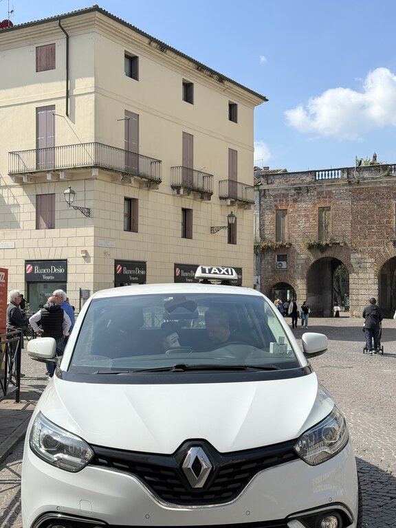 A white taxi parked in a small piazza in Vicenza, northern Italy