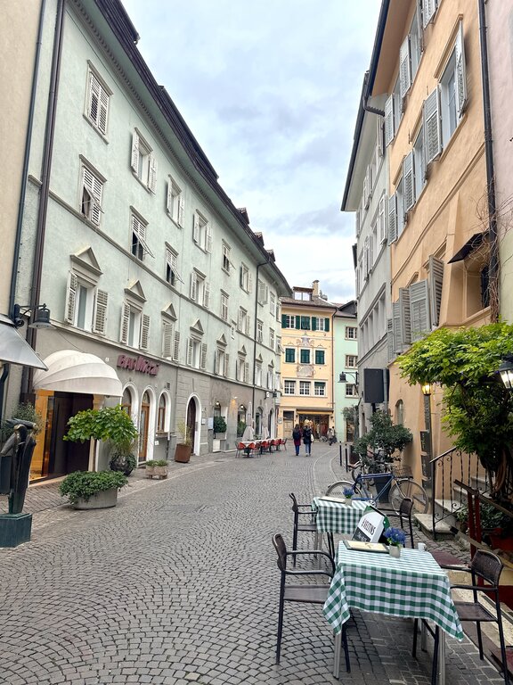 A street with tables and chairs outside in Bolzano, the Dolomites
