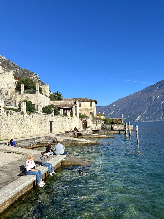 People sitting by the water in Limone sul Garda - 1 day in Lake Garda