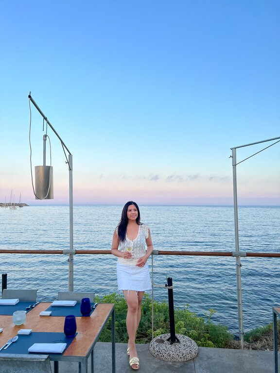 Lisa Rivera at a restaurant in Sardinia Italy at sunset - what to wear in Italy by season