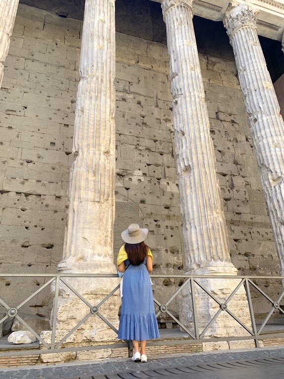 Lisa Rivera at the Pantheon in Rome wearing a yellow shawl over a long blue sundress, an example of how to dress for churches in Italy
