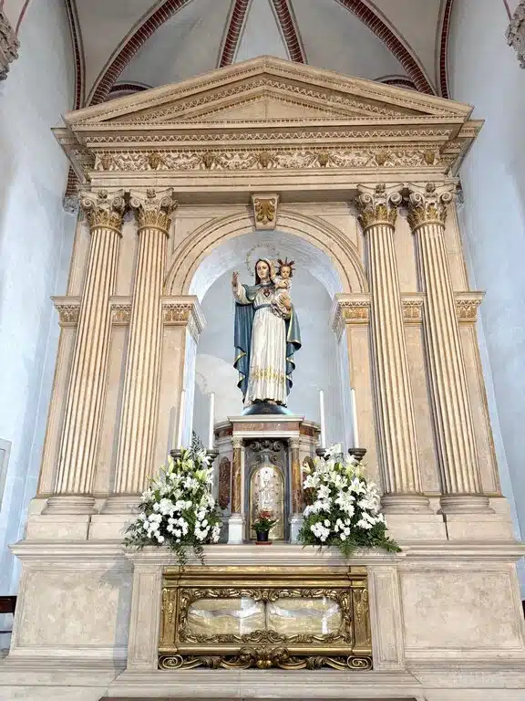 A traditional painted wooden statue of the Virgin Mary (Lady Madonna) inside a local Italian church, typical of the statues used in Easter Sunday ‘running Madonna’ processions