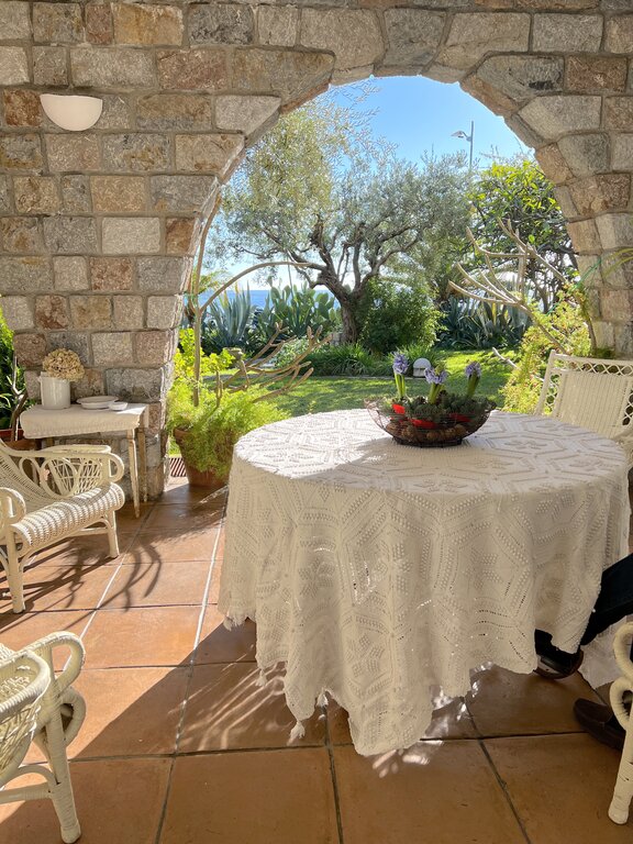An outdoor table and chairs overlooking a garden and the Ionian Sea at Santa Teresa di Riva, where Lisa Rivera and her family live in Sicily
