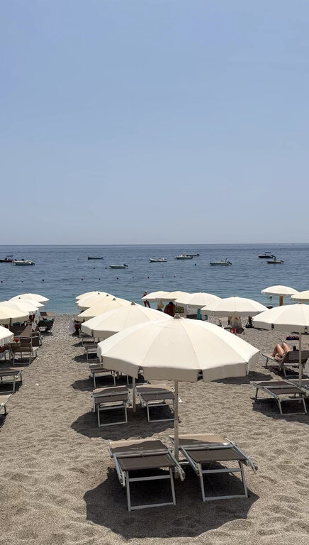 Rows of umbrellas and sun loungers on the lido section of Letojanni beach, a quieter alternative to Taormina's busier beaches on Sicily's Ionian coast